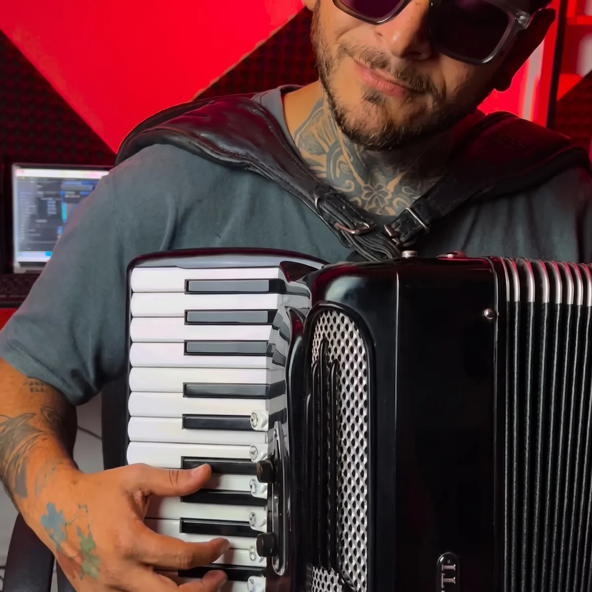 Clayton Gama tocando sanfona no estúdio, sob luz vermelha